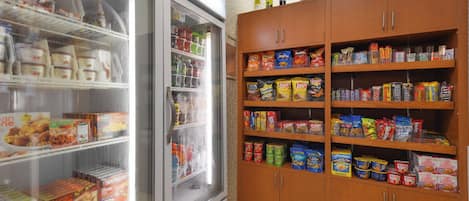 Un refrigerador con alimentos y una despensa llena de provisiones diversas.