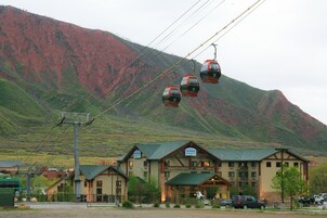 Um hotel com telhado verde, várias janelas e uma placa.