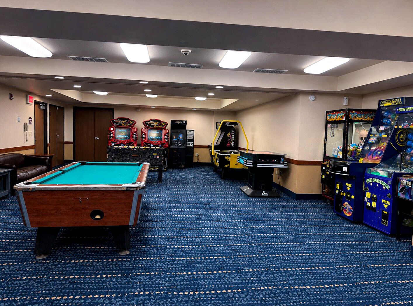 Ein Raum mit Poolbillard, Spielautomaten und einer Billardkugel.