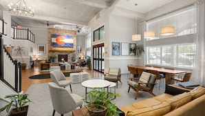 A spacious living area with a fireplace, comfortable seating, and large windows. - Hotel Glenwood Springs (Glenwood Springs)