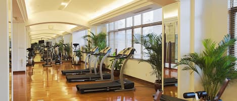 A gym with treadmills, stationary bikes, and weight machines.