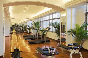 Une salle de sport équipée de tapis de course, de vélos d’appartement et d’appareils de musculation.