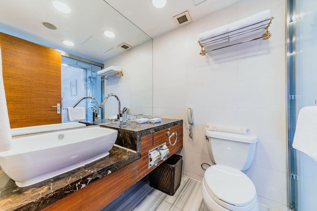 A modern bathroom with a large sink, vanity, and toilet.