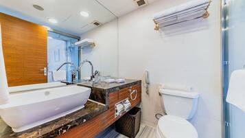 Un baño moderno con un lavamanos grande, tocador e inodoro.