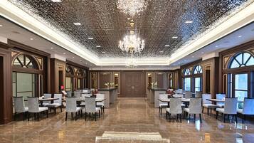 Eine großzügige Lobby mit hoher Decke, einem zentralen Chandelier und einem Marmorboden.