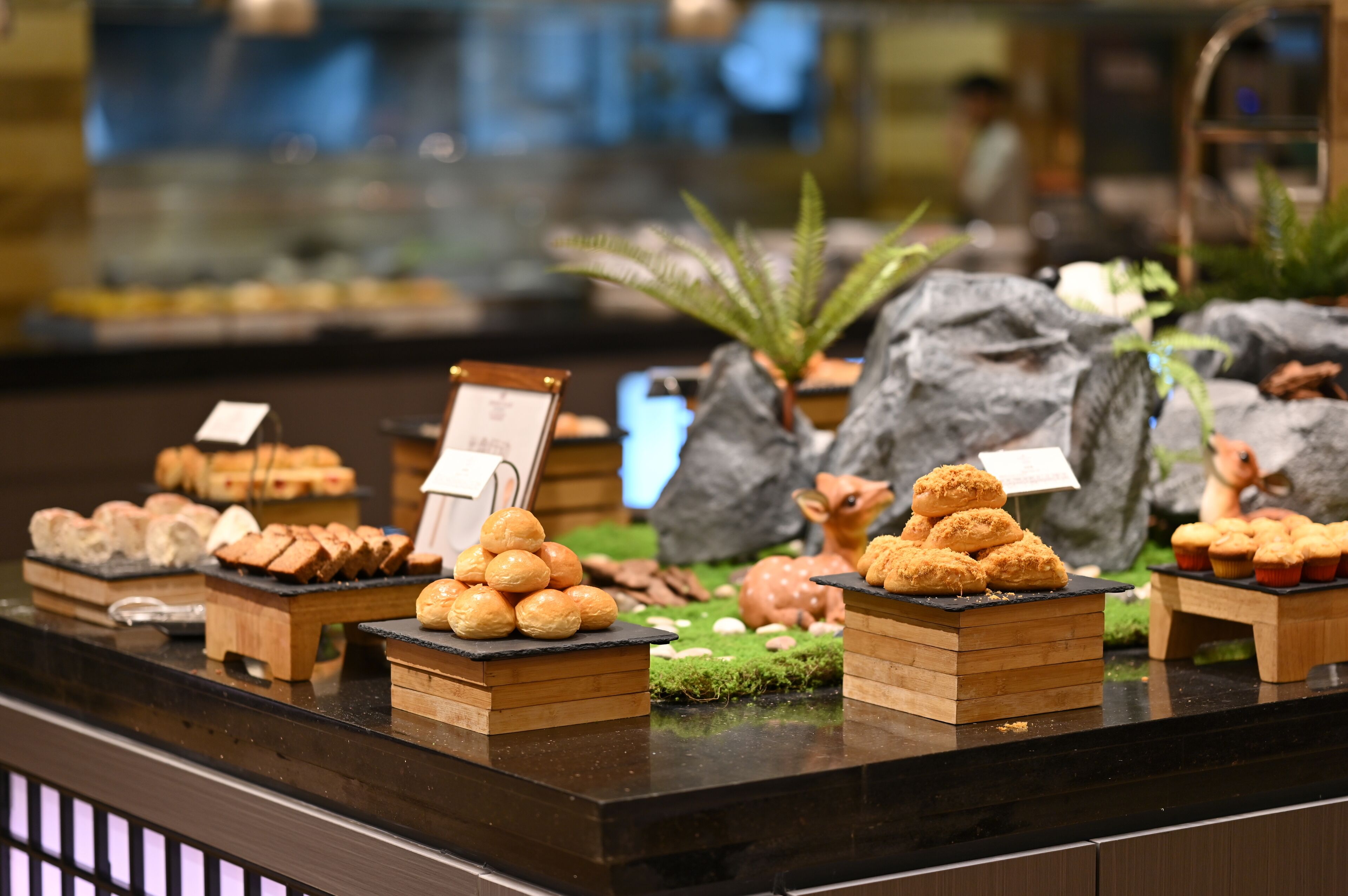 A bakery display with various pastries and a small sign.