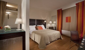 Una camera d'albergo con un letto, comodini, una scrivania e una sedia.