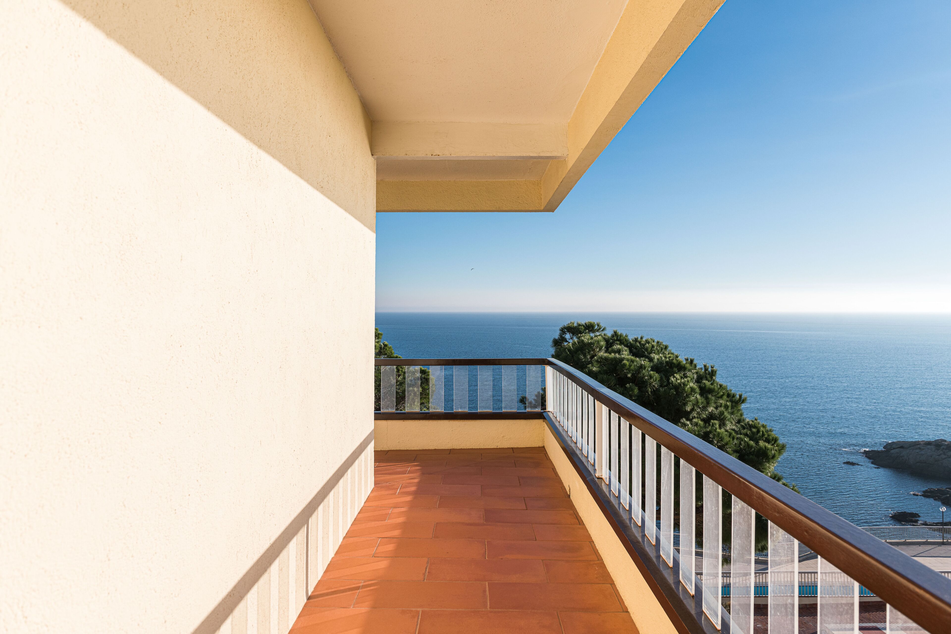 Un balcón con vista al mar y a la costa rocosa.