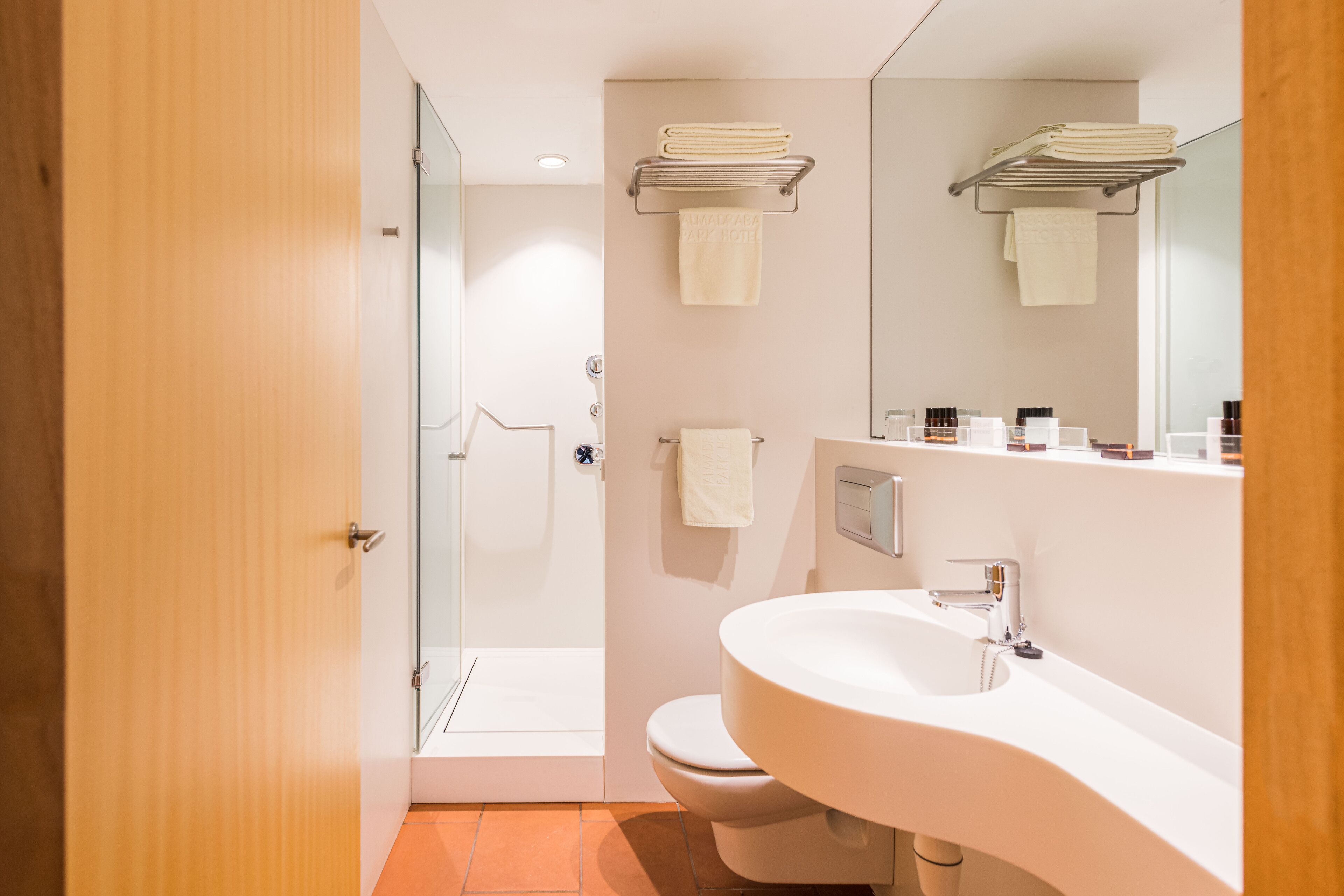 A modern bathroom with a shower, toilet, and sink.