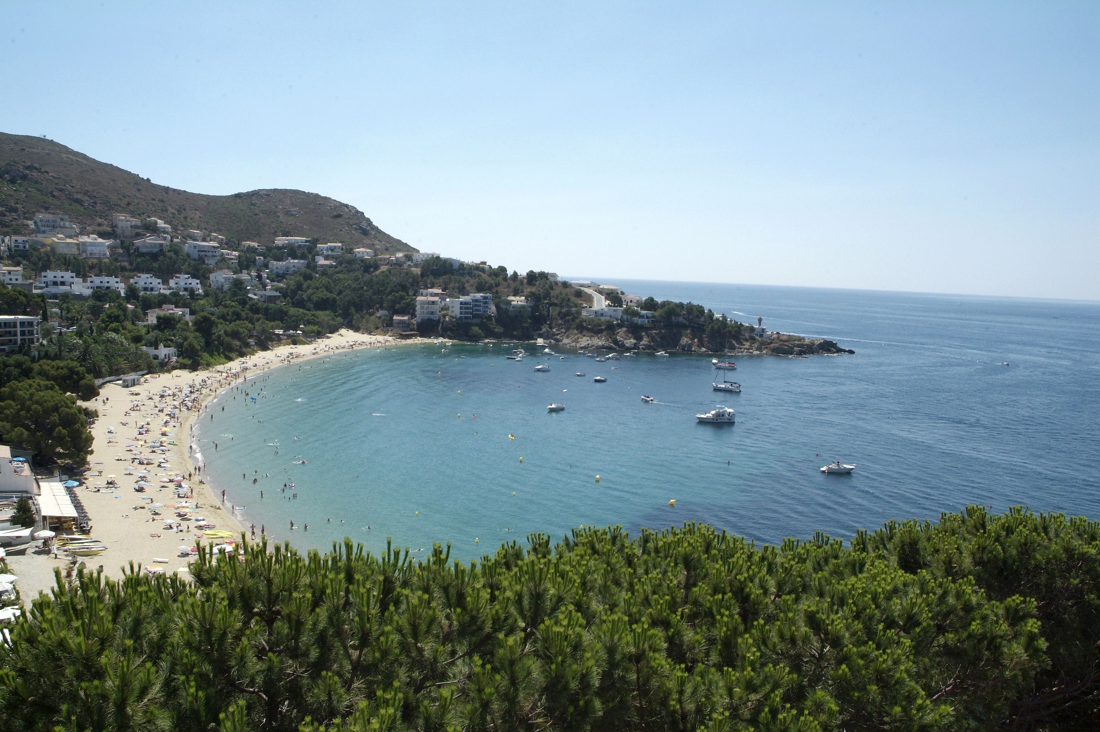 Un pueblo costero con playa, barcos y edificios.
