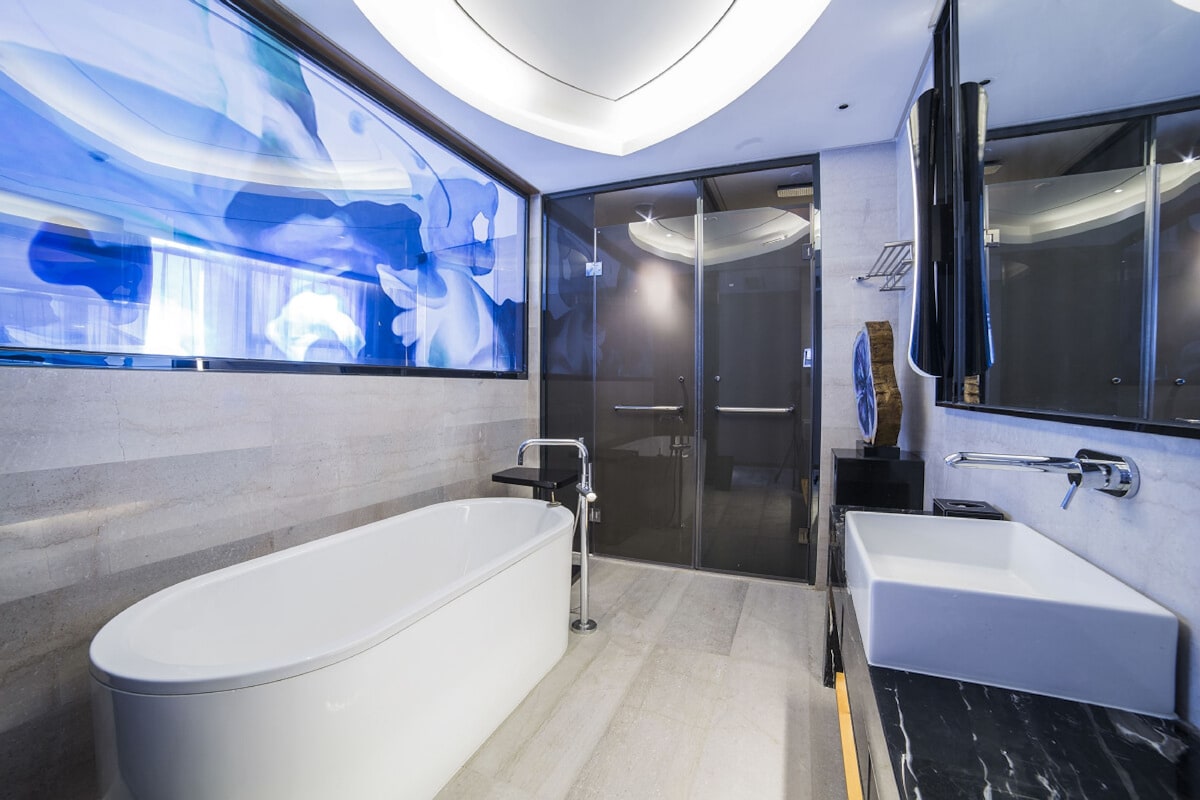 Un baño moderno con una bañera independiente, un lavamanos separado y un box de ducha de vidrio.