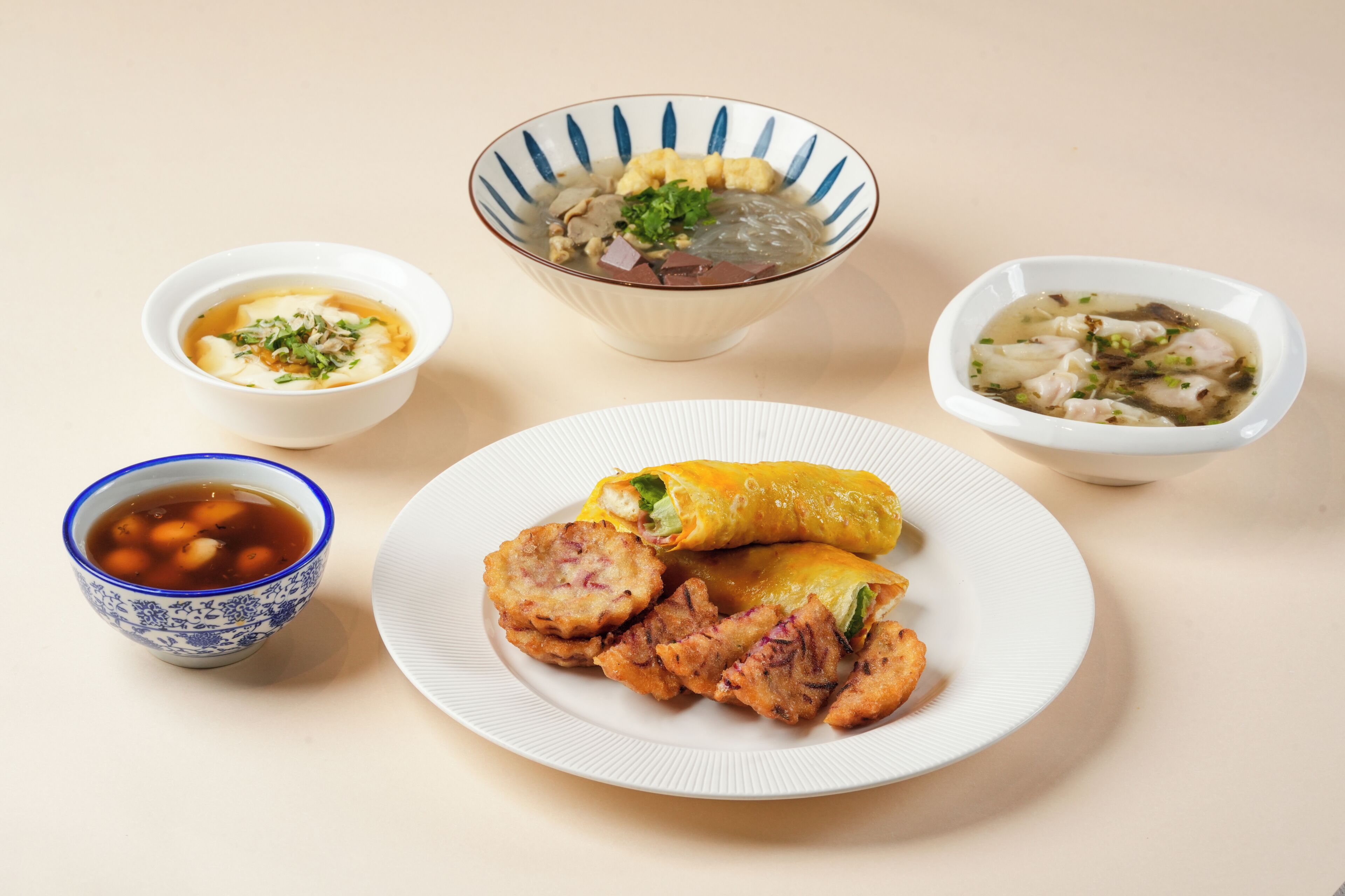 A variety of dishes including a bowl of soup, a plate with fried items, and a bowl of soup with dumplings.