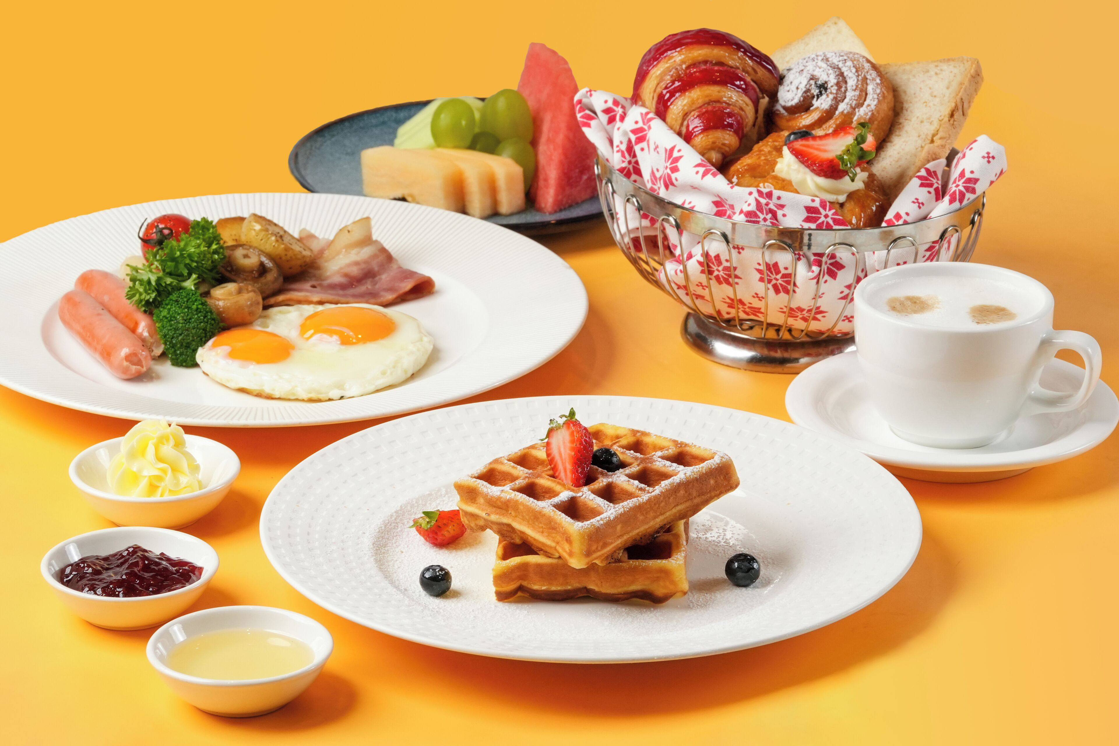 A breakfast setting with plates of food, a waffle, and a cup of coffee.