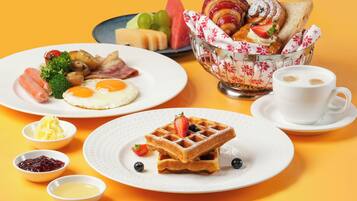 A breakfast setting with plates of food, a waffle, and a cup of coffee.