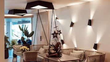 Un interior moderno con un sofá, sillas, una mesa y lámparas colgantes.
