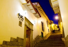 Una escalera conduce a la entrada de un hotel, con un cartel sobre la puerta.