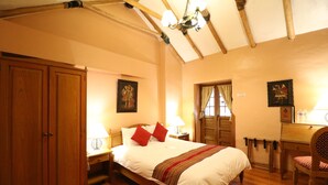 A bedroom with a large bed, wooden wardrobe, and a desk with a chair. - Hotel & Mirador Los Apus (Cusco)