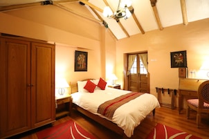 Un dormitorio con una cama grande, un armario de madera y un escritorio con una silla.