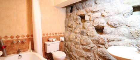 A bathroom with a bathtub, toilet, and sink.