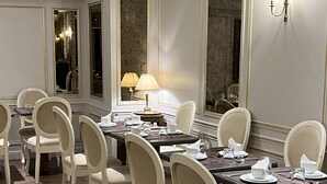 Un comedor elegante con una larga mesa, varias sillas y una lámpara.