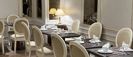 Un comedor elegante con una larga mesa, varias sillas y una lámpara.