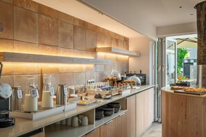 Una cocina moderna con barra desayunadora, diversos alimentos y una estación de café.