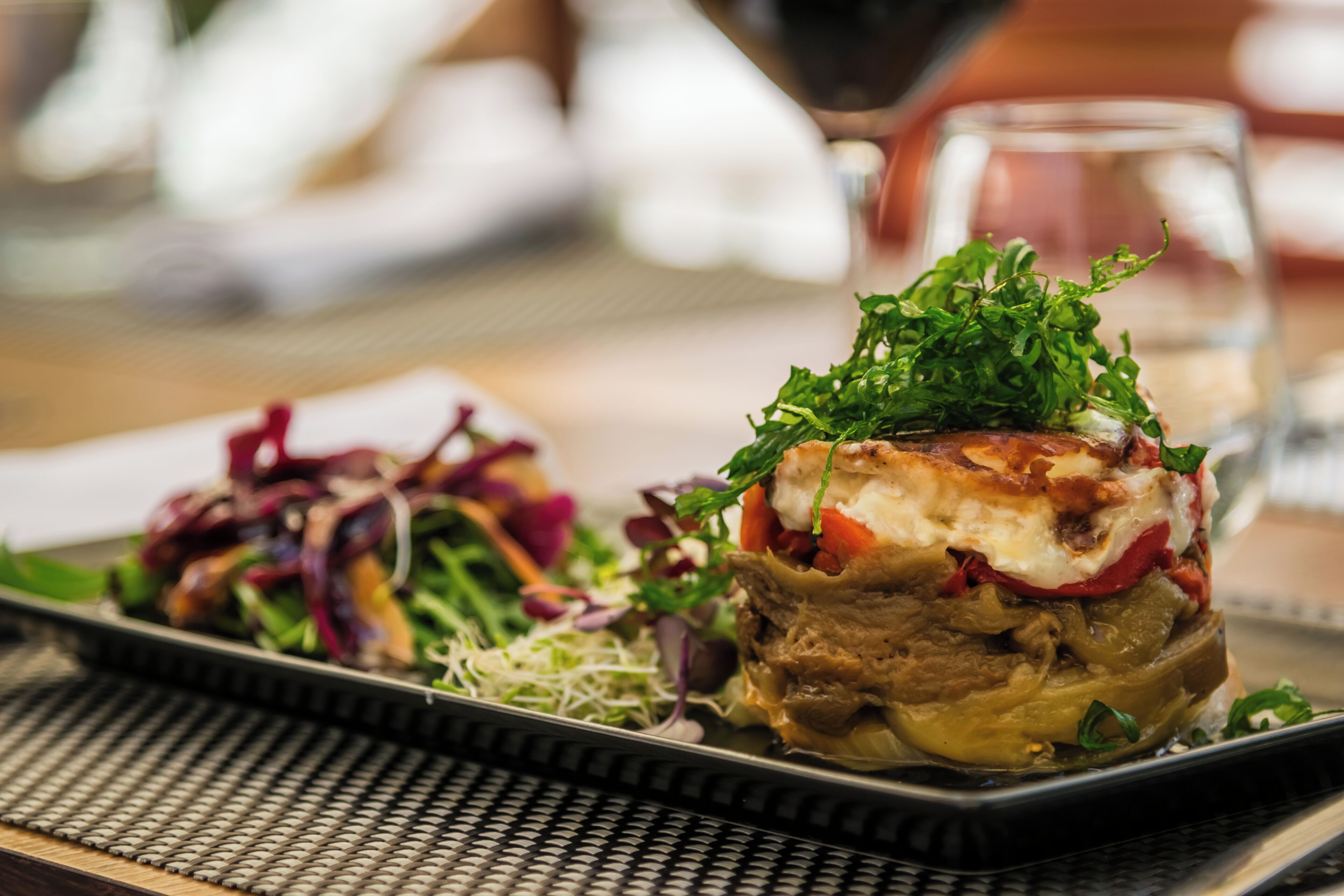 Un plat composé de différentes sortes de légumes et d’un morceau de viande, peut-être un steak, agrémenté de verdure.