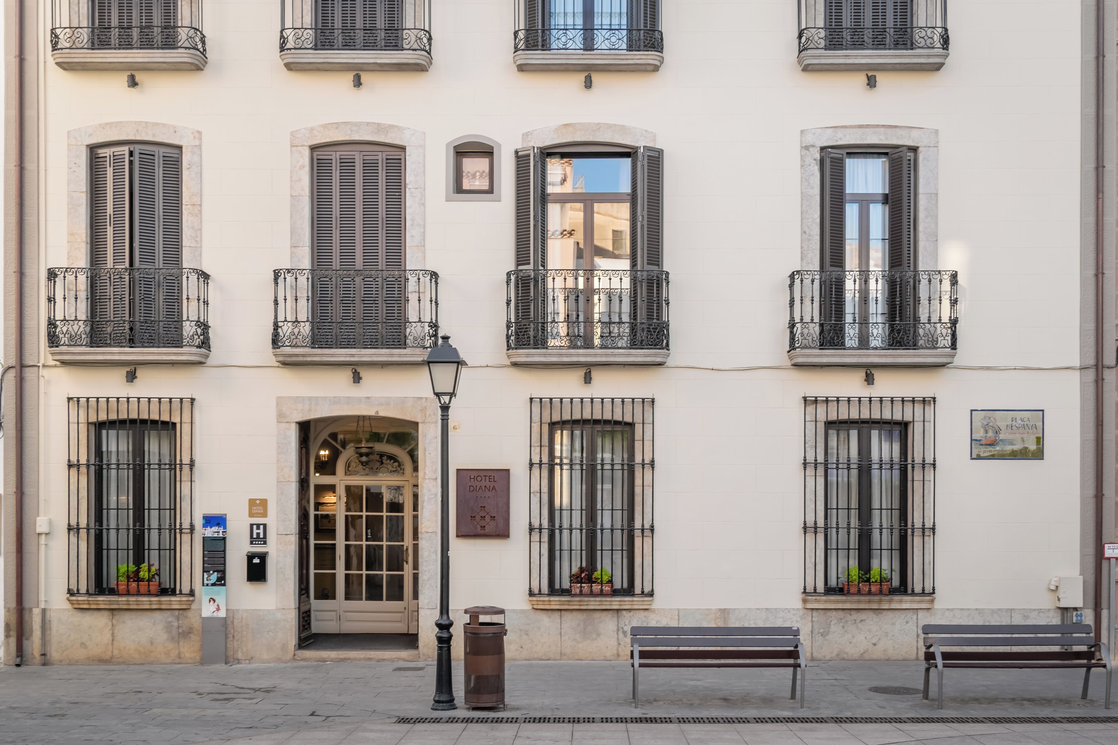 La façade d’un hôtel, ornée de nombreux balcons, avec une entrée centrale et une enseigne indiquant le nom de l’hôtel.
