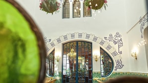 Una habitación con un arco, plantas colgantes e iluminación empotrada.