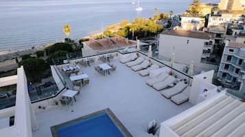 Una piscina al aire libre de temporada, sillones reclinables de piscina