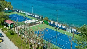 Una cancha de tenis con vista al mar.
