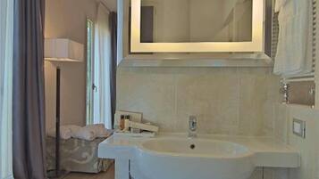 Une salle de bain moderne avec un grand miroir, un lavabo et un porte-serviettes.