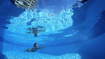 Vista subacuática de una piscina con agua cristalina y bordes bien definidos.