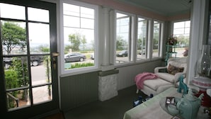 A porch with a view of the street, a chair, a table with a teapot, and a window with a view of the street. - Rose Arden Bed & Breakfast (Hamilton)