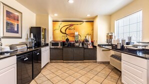 A modern kitchen with a coffee station, a microwave, and a toaster. - Rodeway Inn (Temple)