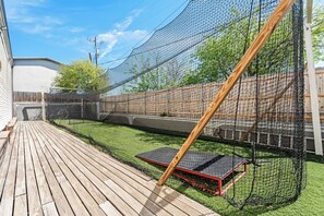 A backyard with a wooden deck, a trampoline, and a netted play area. - Rodeway Inn (Temple)