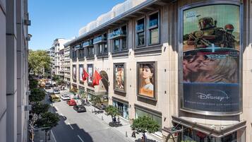 Un edificio de varios pisos con grandes carteles que publicitan diversas marcas y películas.