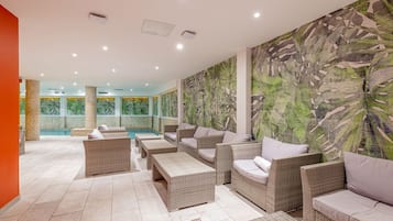 Una piscina techada, sillones reclinables de piscina