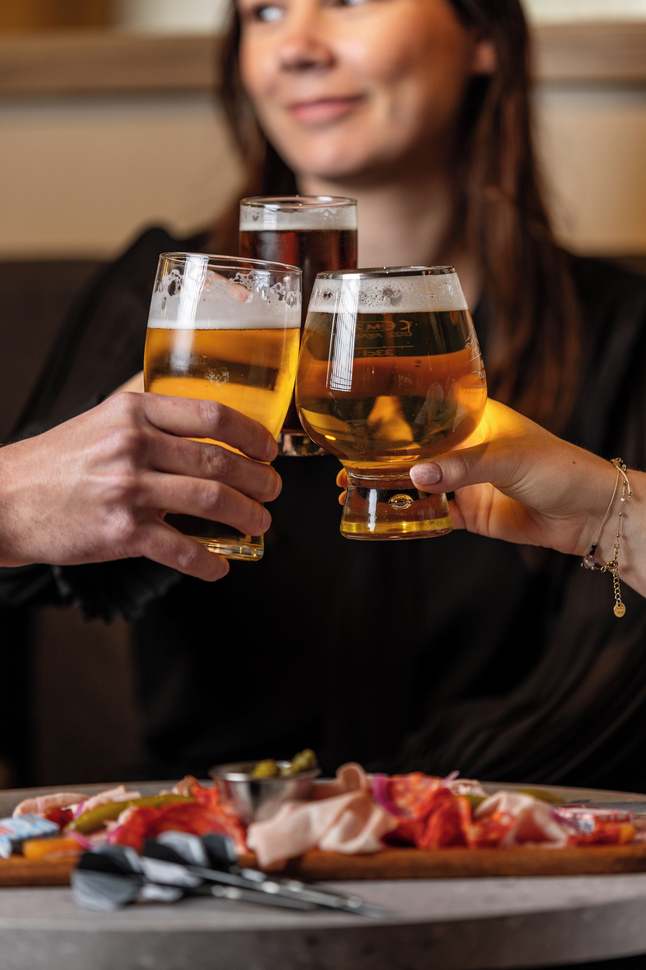 Two people holding glasses of beer.