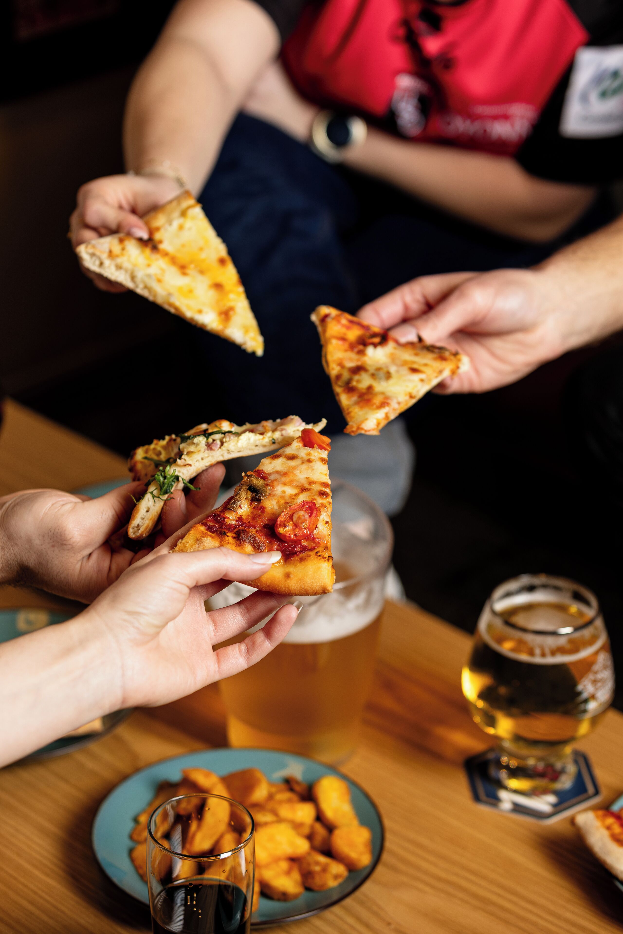 A person holding a slice of pizza.