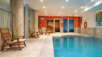 Una piscina techada, sillones reclinables de piscina