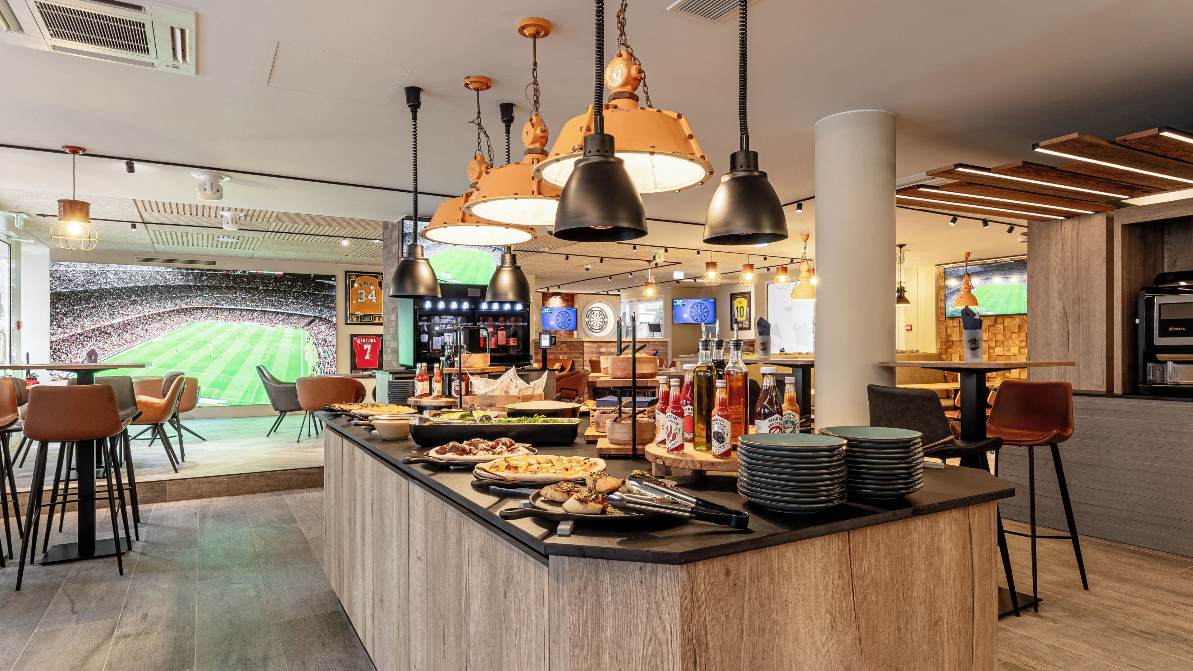 A restaurant with a bar area, sports-themed decor, and a view of a stadium.