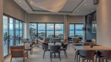 Un espacio interior amplio con diversas opciones de mobiliario, ventanas grandes que ofrecen vistas al exterior y un diseño de techo moderno.