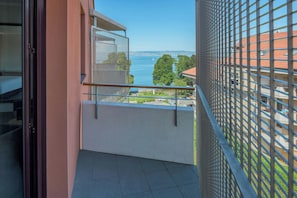 Un balcón con vista al mar y al paisaje urbano.