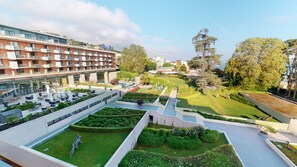Un hôtel comprenant plusieurs étages, des espaces de détente en plein air et des jardins bien entretenus.