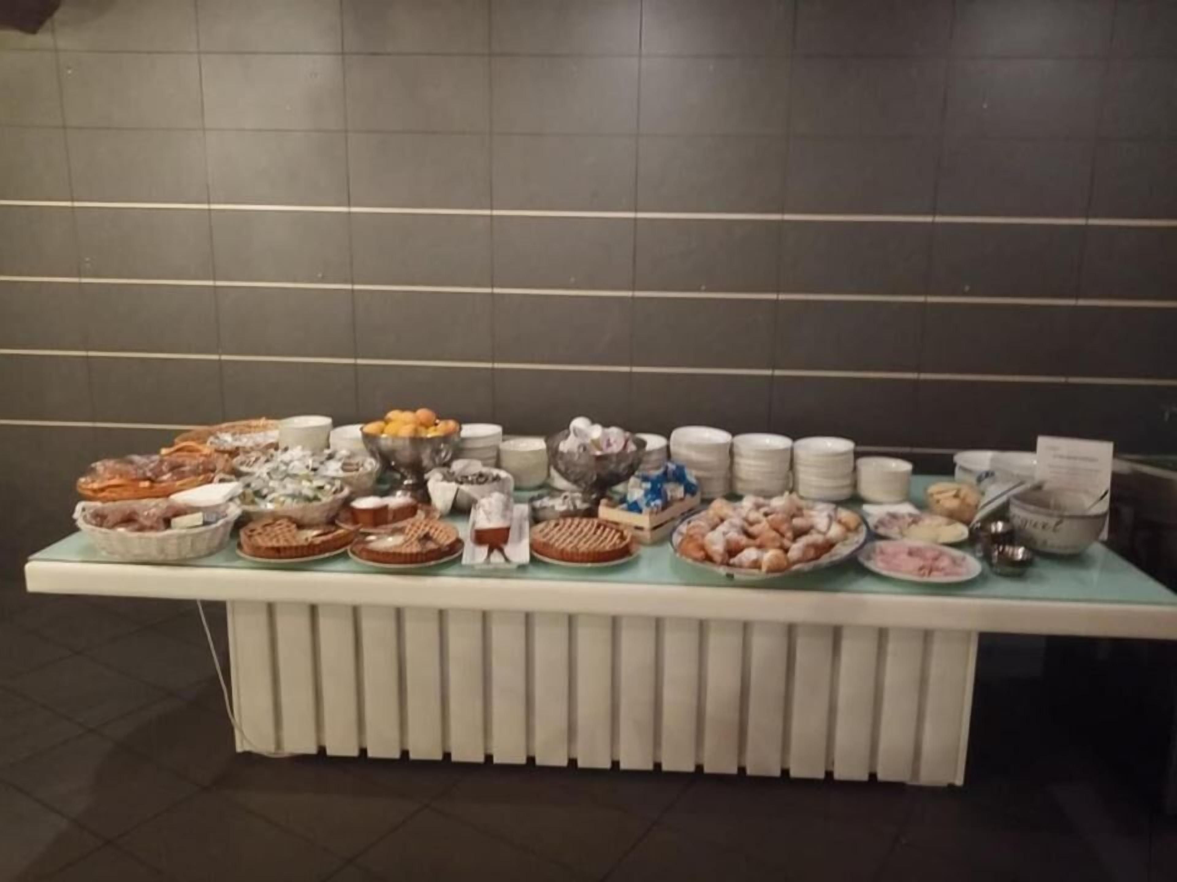 A buffet table with various food items and dishes.