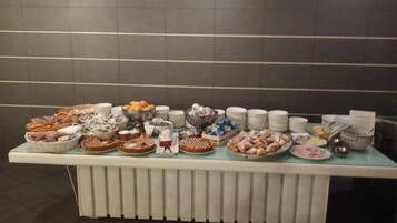 Uma mesa de buffet com diversos alimentos e pratos.