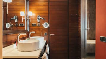 Un baño moderno con dos lavamanos, un espejo grande y un secador de pelo.