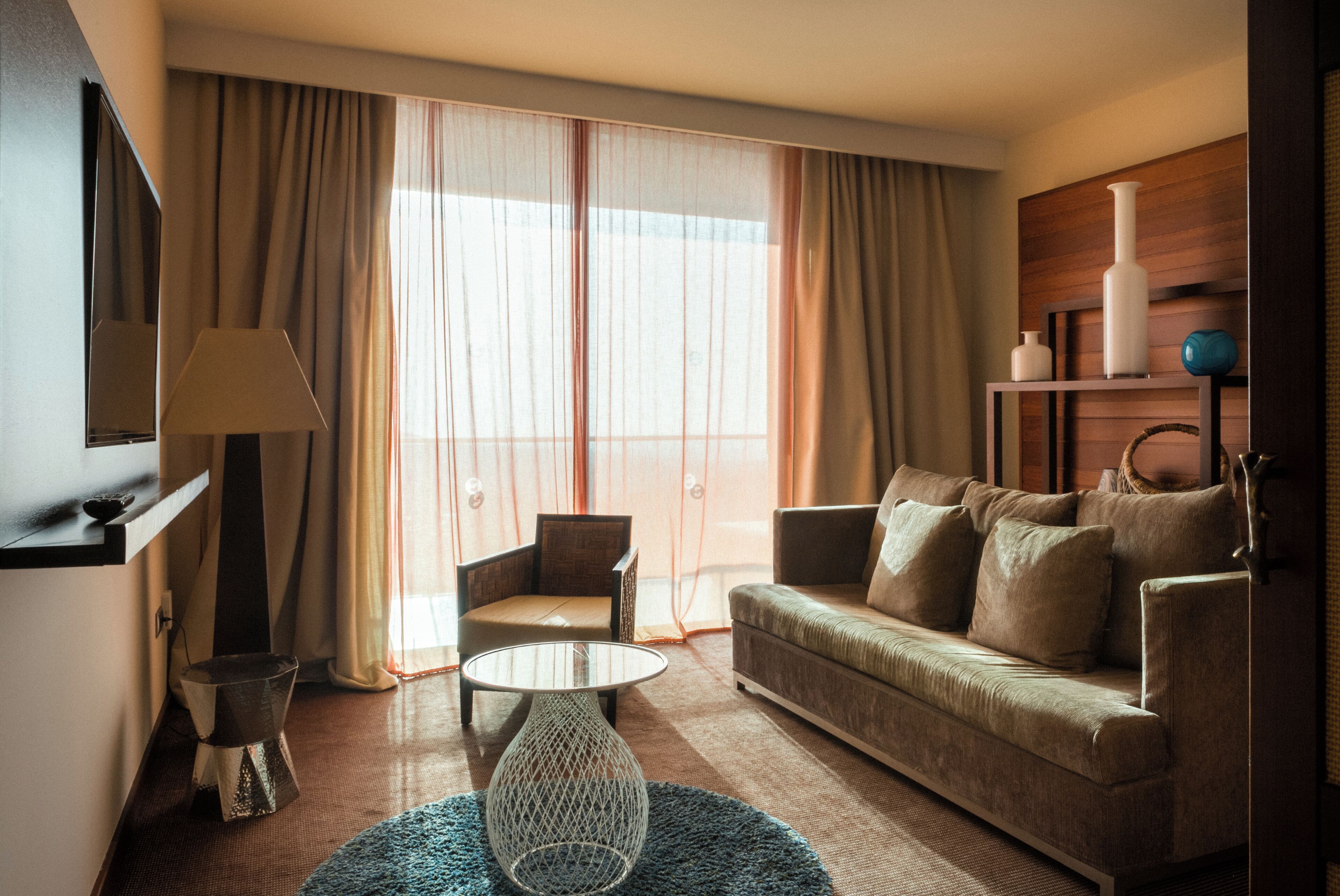 Habitación de hotel con sofá, sillón y una pequeña mesa.