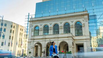 A hotel with a classical facade and a modern glass building above.
